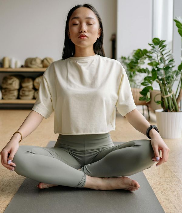 A person sitting peacefully with eyes closed after a light workout session.